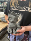 Person holding a concrete sculpture of a face