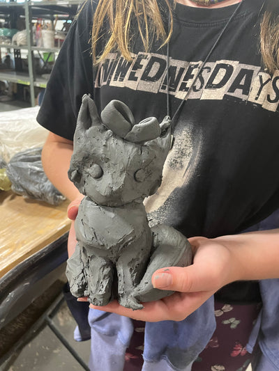 Person holding a concrete sculpture of a face