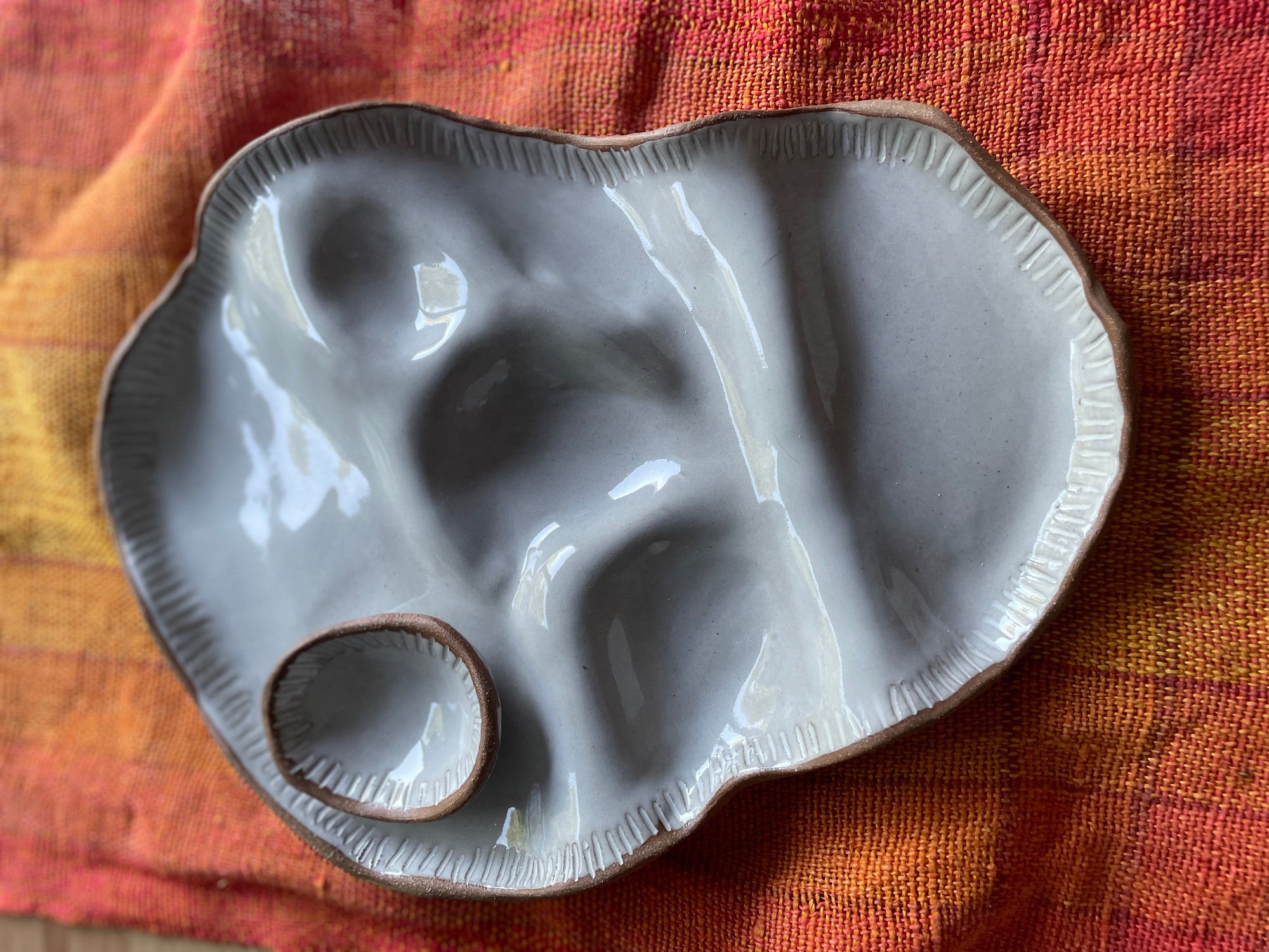 Ceramic sharing plate on a textured orange woven placemat